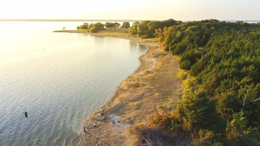 Lavon Lake shoreline in Wylie Texas with people fishing at sunset